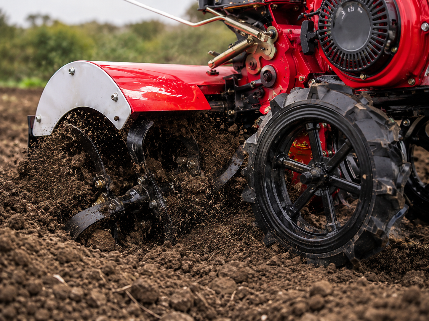 Close-up of rotary tiller blades digging into soil